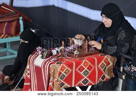 Moscow, Russia - July 14, 2018: A Senior And Young Arabian Women Make A Traditional Sadu Weaving. Qa