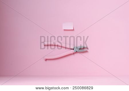 Pink Pliers On The Table With A Sticker