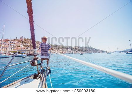 Cute Boy On Board Of Sailing Yacht On Summer Cruise. Travel Adventure, Yachting With Child On Family