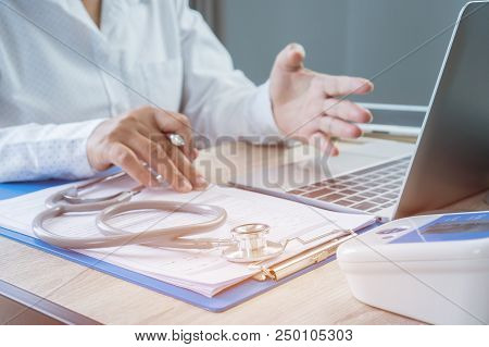 Medicine Doctor Hand Explaining For Patient At Consulting Room, Working On Laptop Computer On Desk I