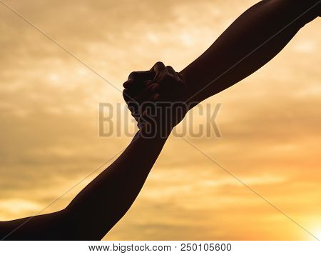Closeup Helping Hands On The Sunset Sky Background. Rescue & Help Cencept