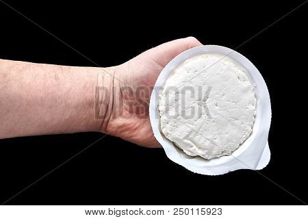 Cottage Cheese In Plastic Packaging Lying On The Hand . Isolated On Black Background. Curd - Dairy, 
