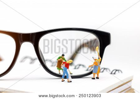 Miniature People Worker Cleaning Eyes Glasses On Book. Clear Vision Concept.
