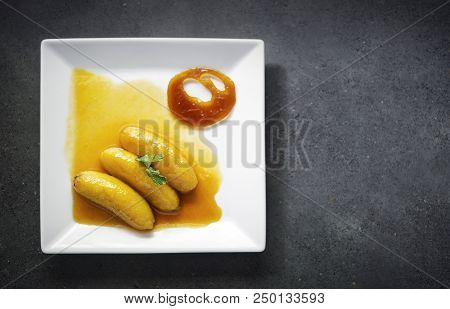 Gourmet Flambeed Fried Banana In Orange Juice Reduction Sauce And Tangerine Caramel Chip