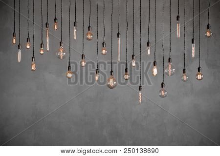Edison Retro Lamp Incandescent Bulbs On Gray Plaster Wall Background In Loft. Concept Vintage Style.