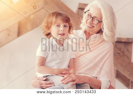 Love Him To The Moon And Back. Beautiful Senior Woman Grinning Broadly While Looking At Her Cut Litt