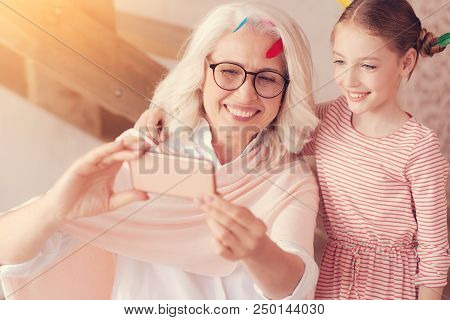 Say Cheese. Adorable Shot Of Beaming Senior Woman And Her Smart Preteen Granddaughter Smiling Cheerf