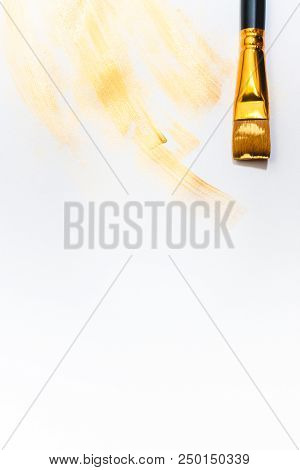Beautiful Golden Strokes And A Brush Isolated On White Background.