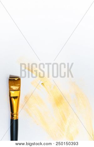 Beautiful Golden Strokes And A Brush Isolated On White Background.