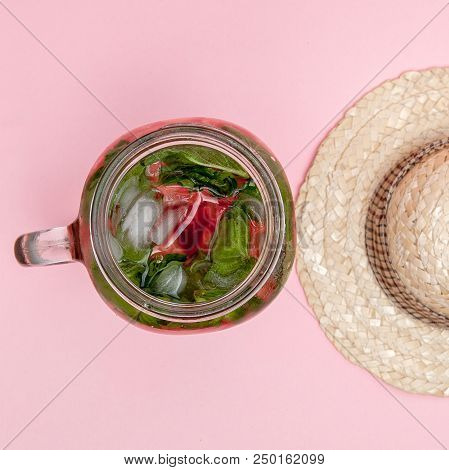 Jar Of Cold Fresh Lemonade With Piece Of Watermelon And Ice On Pink Background.
