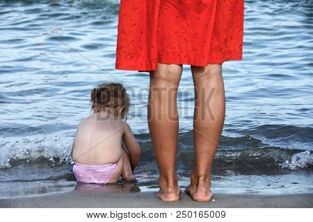 Refugees Girl And Mother Standing Near Sea Shore