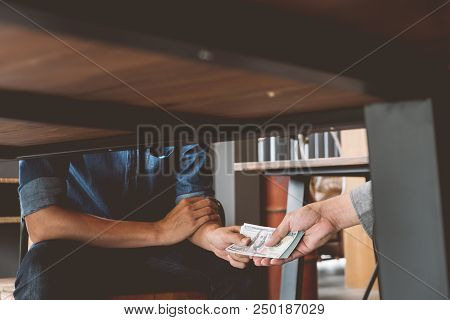 Bribery, Hands Passing Money Under Table, Corruption And Bribery Concepts.