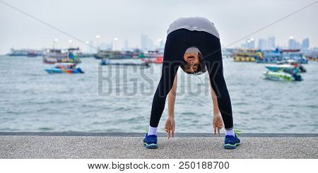 Sports Concept. Beautiful Girl Is Exercising On The Beach With Warm Up. Beautiful Girl Is Happy To E