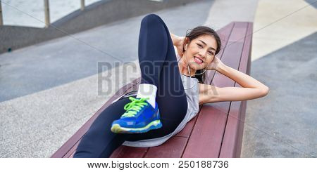 Sports Concept. Beautiful Girl Is Exercising On The Beach With Warm Up. Beautiful Girl Is Happy To E