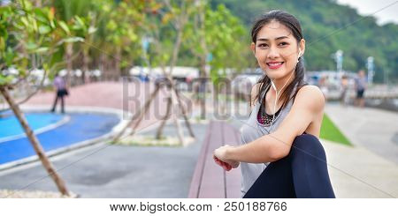 Sports Concept. Beautiful Girl Is Exercising On The Beach With Warm Up. Beautiful Girl Is Happy To E