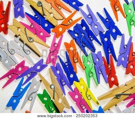 Colored  Wooden Clothes Pegs On A White Background