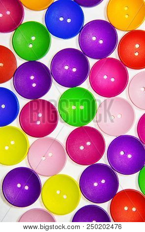 Colored Multicolored Wooden Buttons In The Background On White