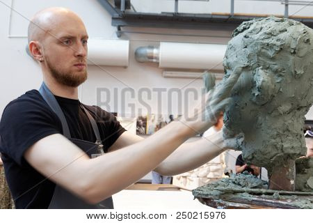 ST. PETERSBURG, RUSSIA - JULY 15, 2018: Sculptor Vitaly Datchenko participates in artistic battle during the opening of festival Laboratory Of Sculpture in the museum workshop of sculptor M. Anikushin