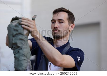 ST. PETERSBURG, RUSSIA - JULY 15, 2018: Sculptor Pyotr Subbotin participates in artistic battle during the opening of festival Laboratory Of Sculpture in the museum workshop of sculptor M. Anikushin