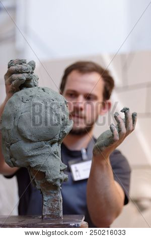 ST. PETERSBURG, RUSSIA - JULY 15, 2018: Sculptor Danila Reshetov participates in artistic battle during the opening of festival Laboratory Of Sculpture in the museum workshop of sculptor M. Anikushin