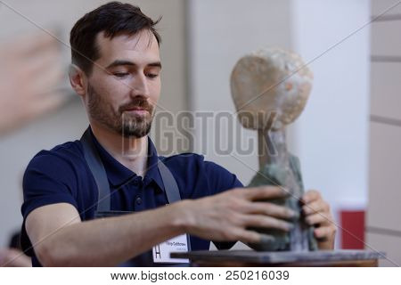 ST. PETERSBURG, RUSSIA - JULY 15, 2018: Sculptor Pyotr Subbotin participates in artistic battle during the opening of festival Laboratory Of Sculpture in the museum workshop of sculptor M. Anikushin