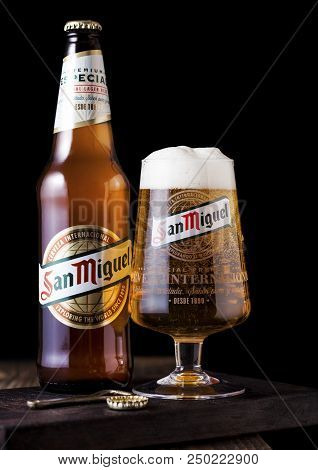 London, Uk - April 27, 2018: Bottle And Original Glass Of San Miguel Lager Beer On Dark Wooden Backg