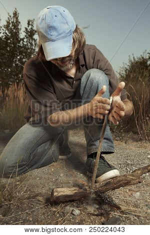 Man In Hat Successfully Made A Fire With Wood Stick Friction