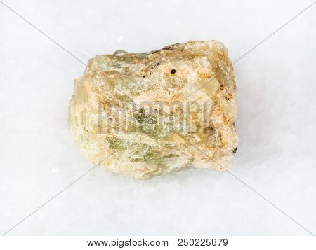 Macro Shooting Of Natural Mineral - Raw Chrysoberyl (green Beryl) Crystal On White Marble From Ural 