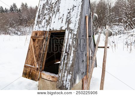 Open Well At The Edge Of The Forest In Russian Village With Old Typical Tools (ice Picks And Ladles)