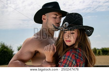 Country And Western Characters Of Cowboy And Cowgirl Fight Next To A Wooden Fence And Grassy Field