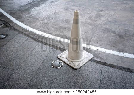 White Traffic Cone On Concrete Road Standing By Walkway Or Footpath