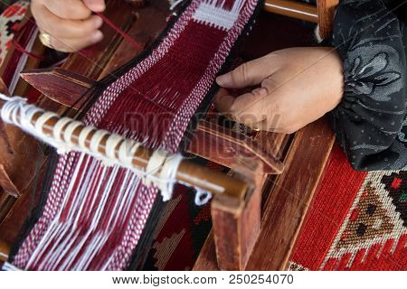 A Senior Arabian Woman Makes A Traditional Sadu Weaving. Hands Of A Weaver Close-up, Focus On The Ha