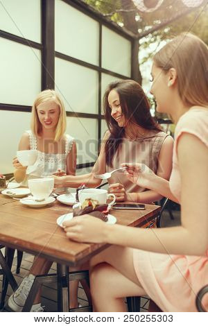 Two Girl Friends Spending Time Together Drinking Coffee In The Cafe, Having Breakfast And Dessert. Y