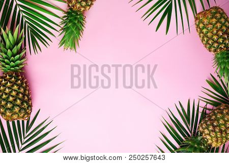 Pineapples And Tropical Palm Leaves On Punchy Pastel Pink Background. Summer Concept. Creative Flat 