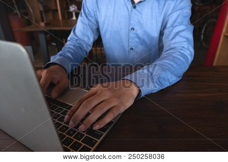 A Man With Laptop On Wooden Table