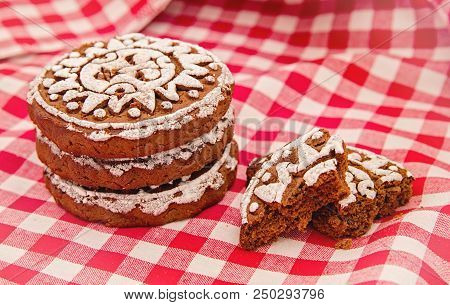 Pile Of Gingerbread Cookies With Two Broken Pieces On Red And White Tradational Tablecloth