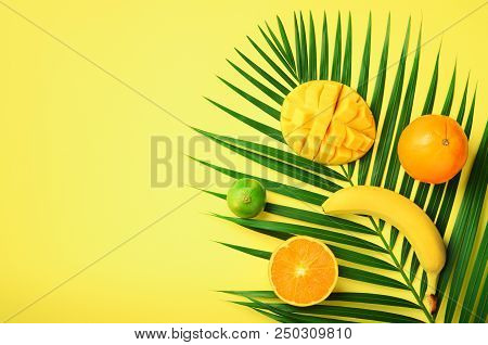Fresh Orange, Banana, Pineapple, Mango Smoothie And Juicy Fruits On Palm Leaves Over Yellow Backgrou