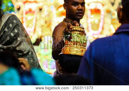 Durgapur, West Bengal, India. July, 2018 A Purohit Panda Blessing A Devotee With Sacred Golden Hat A