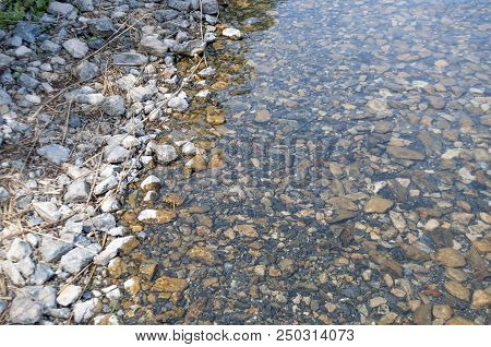 Stony Shore Of The Lake With Clear And Transparent Water