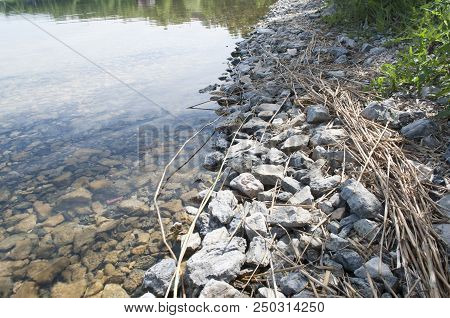 Stony Shore Of The Lake With Clear And Transparent Water