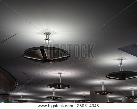 Some Industrial Florescent Lights Hanging On A Modern Ceiling