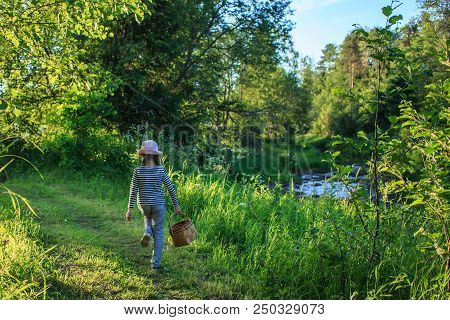 Young Girl Walking On A Path Through Green Woods Carrying A Birchbark Basket