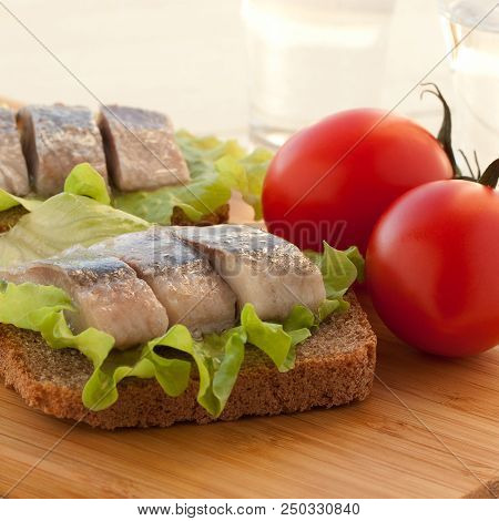 Two Sandwiches Of Rye Bread And Herring With Lettuce And Tomatoes