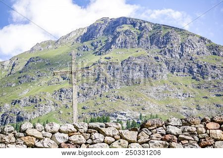 Wooden Cross In An Alpine Valley