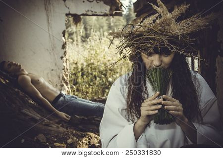 Girl Druid Healer With A Wreath Of Wild Flowers On His Head Holding A Bunch Of Herbs In His Hands An