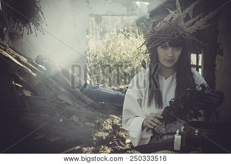 Girl Druid Healer With A Wreath Of Wild Flowers On His Head Holding A Bunch Of Herbs In His Hands An