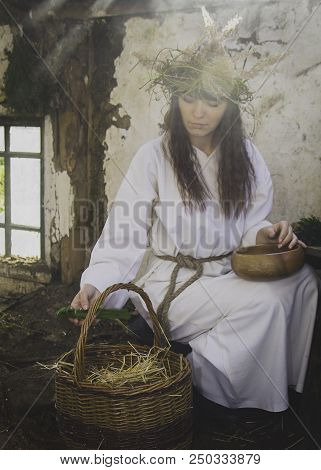 Girl Druid Healer With A Wreath Of Wild Flowers On His Head Holding A Bunch Of Herbs In His Hands An