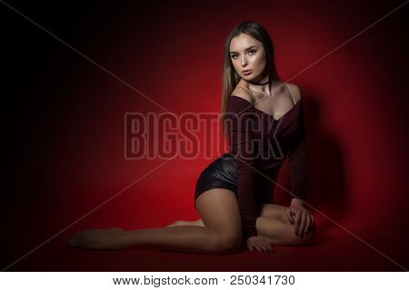 Portrait Of Sexy Woman In Studio Of Red Backgraund