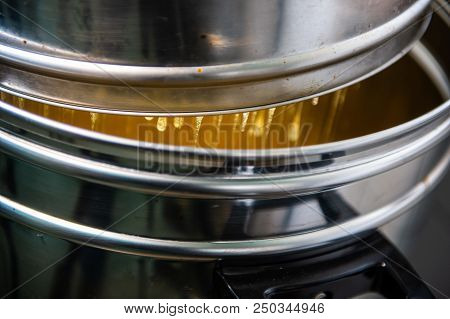 Strain The Poured Honey Through A Sieve. How To Harvest Honey. Filtering Raw Honey.