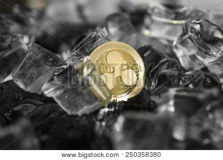 Gold Ripple Coin On Ice Background. The Concept Of The Exchange In Winter. Freeze. Blockchain Mining